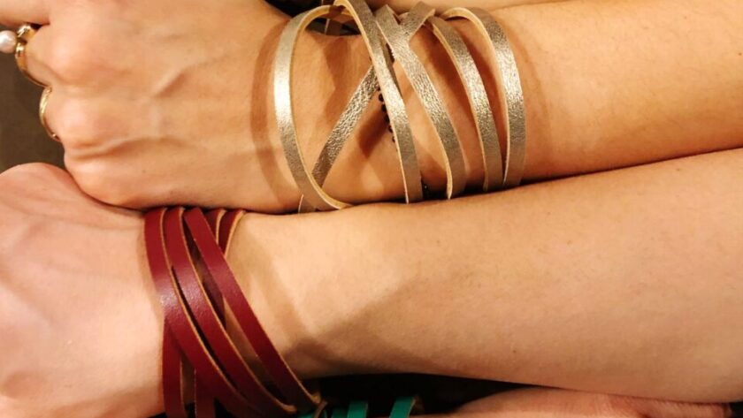 Poignet portant un bracelet semainier composé de sept joncs superposés.